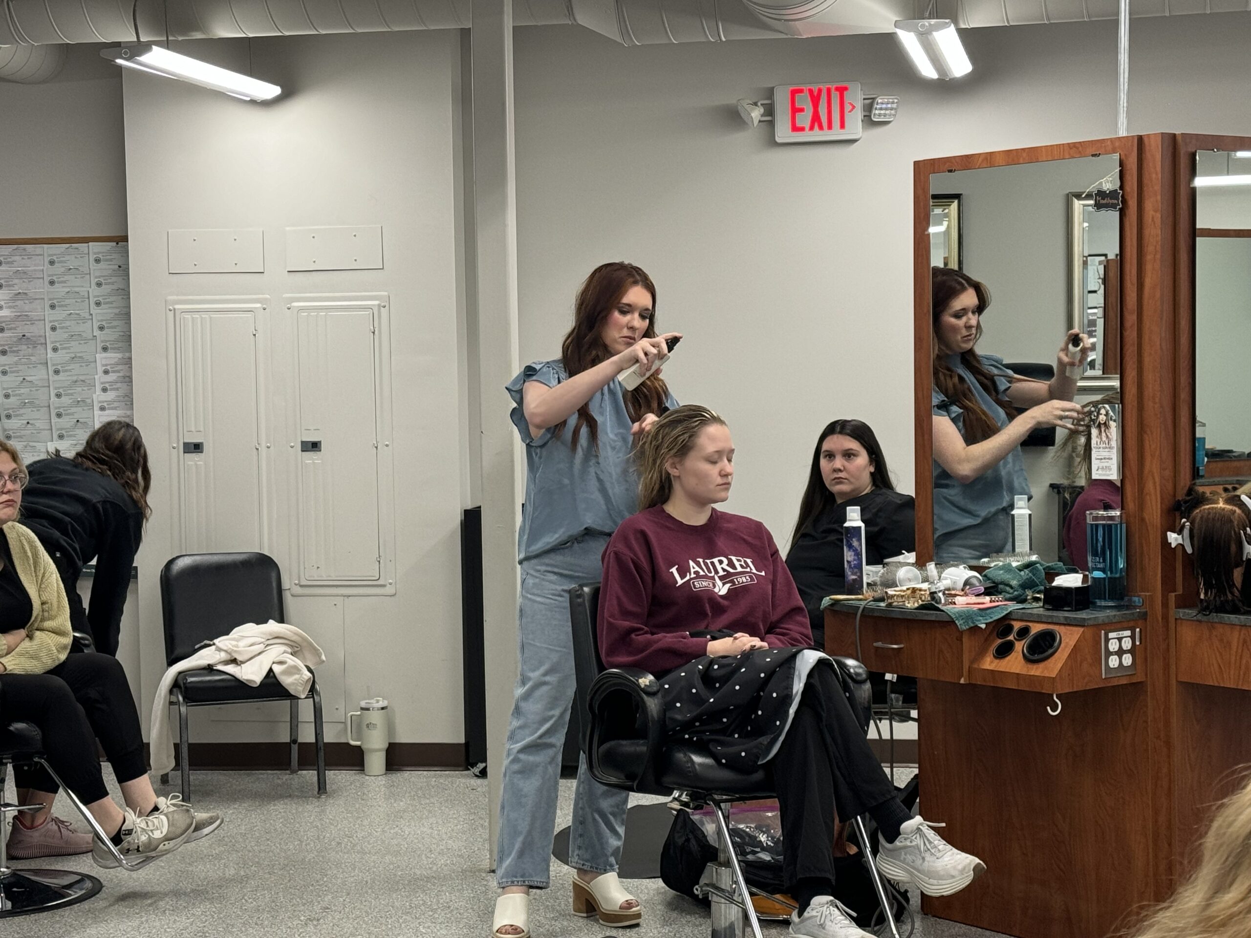 Laurel College of Technology Cosmetology students take time to watch demo from Laurel grad & local Beauty Bar owner.