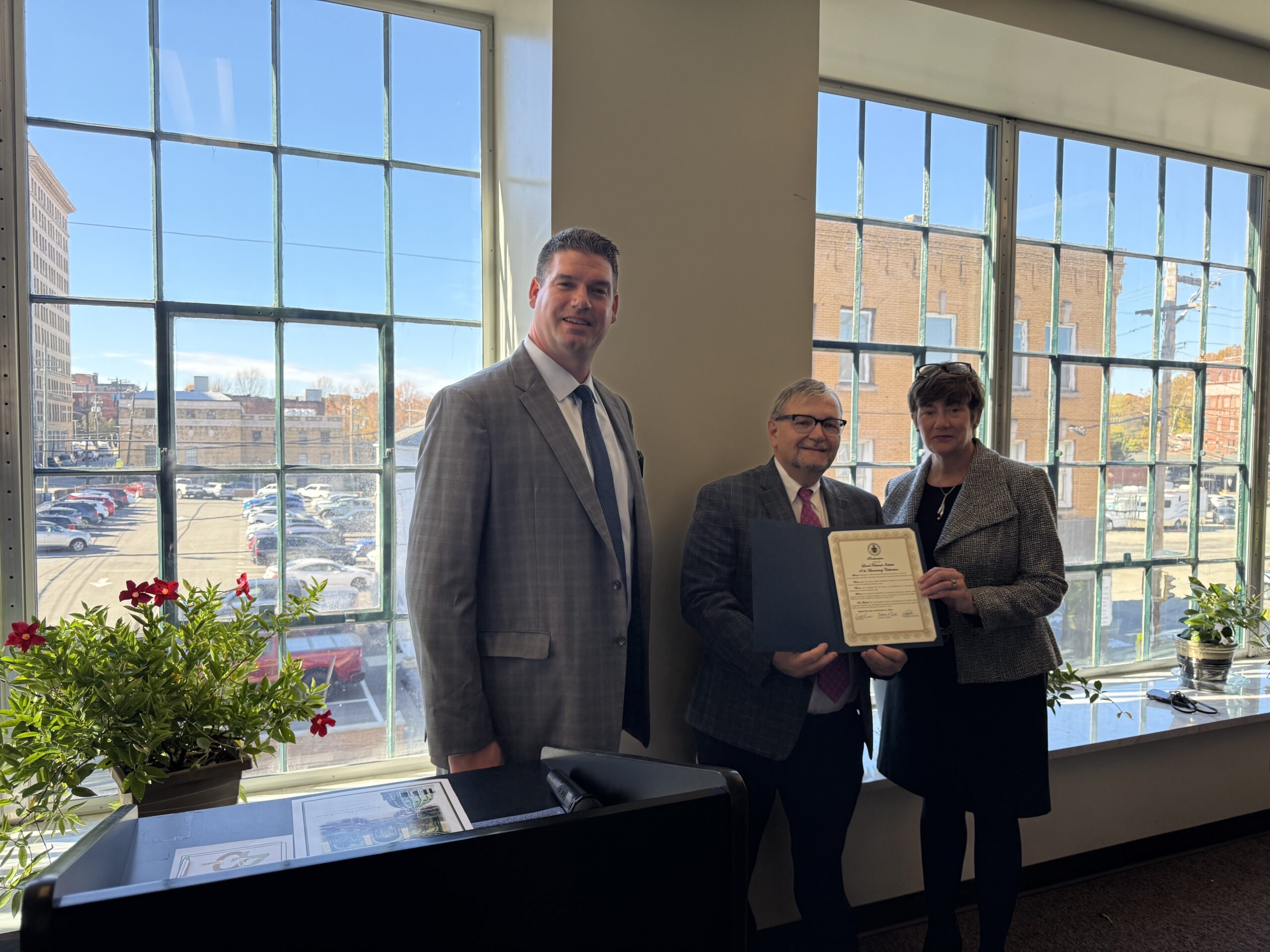 Fayette County Commissioner Vince Vicites presents a certification of appreciation for 40 years of service to the local community, employers, and students.