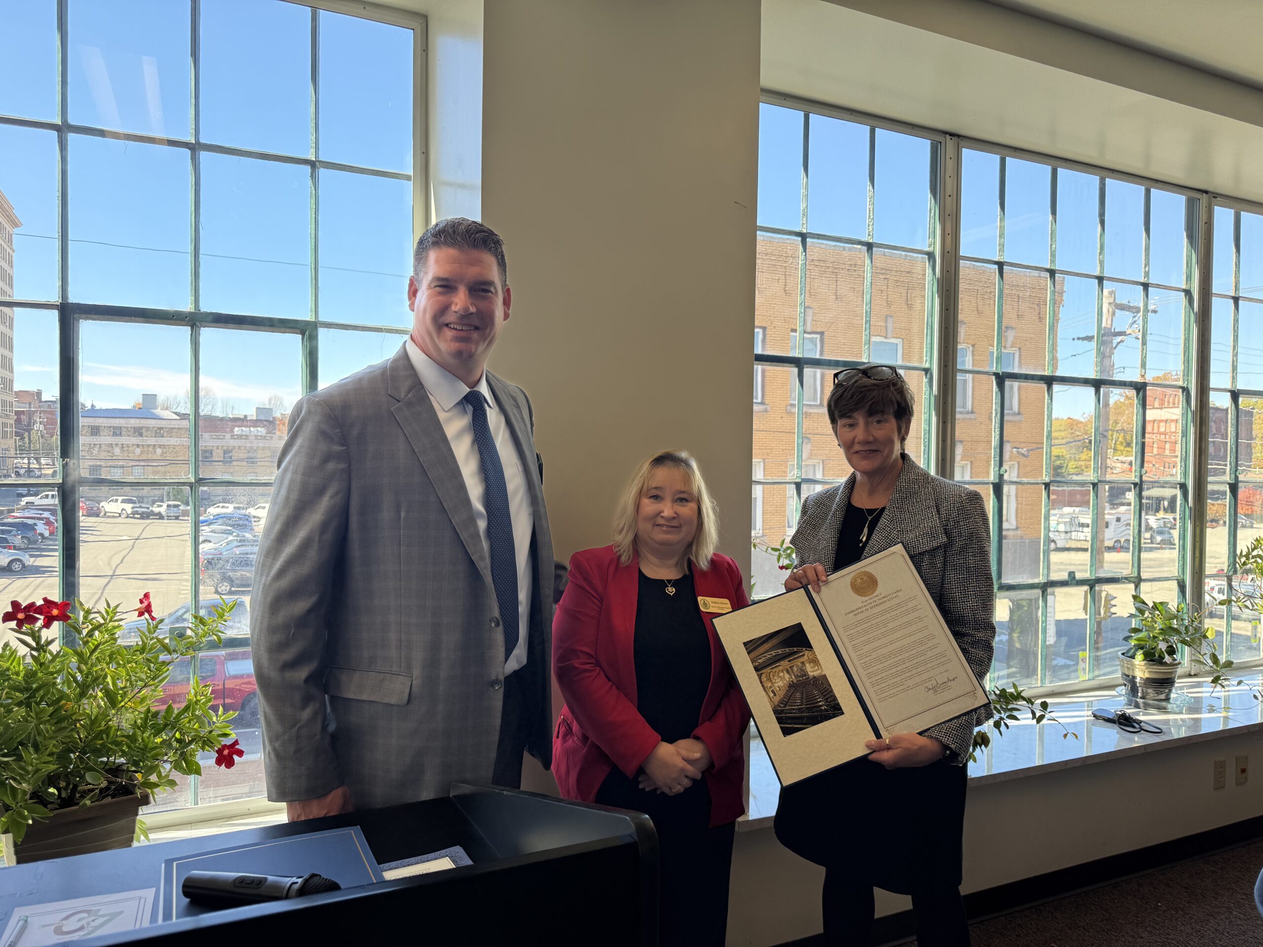 Debbie Hoone, from House of Representatives Charity Grimm Krupa’s office, presents a certificate of recognition for 40 years of service to the community.