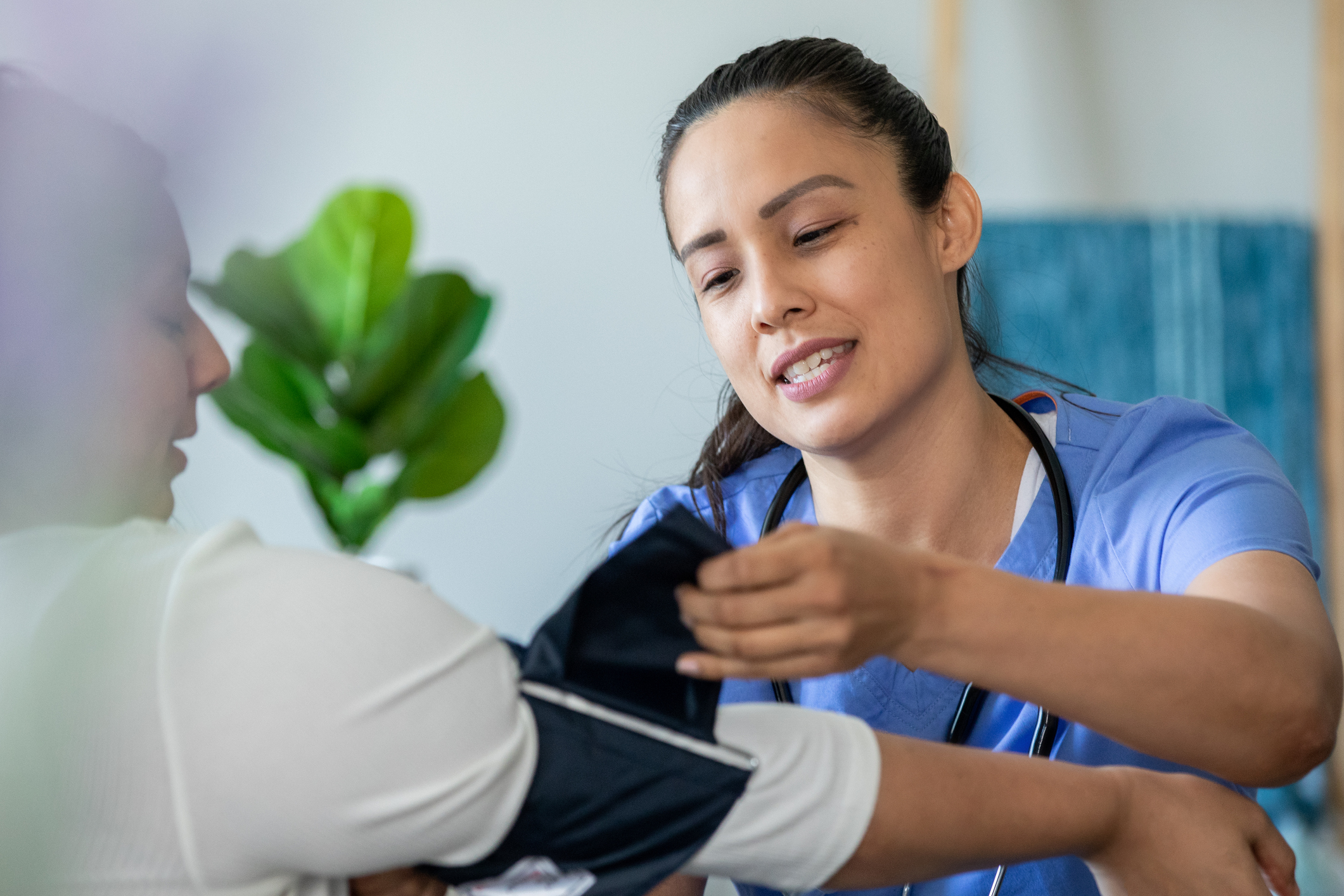 Home health nurse checking her patients blood pressure