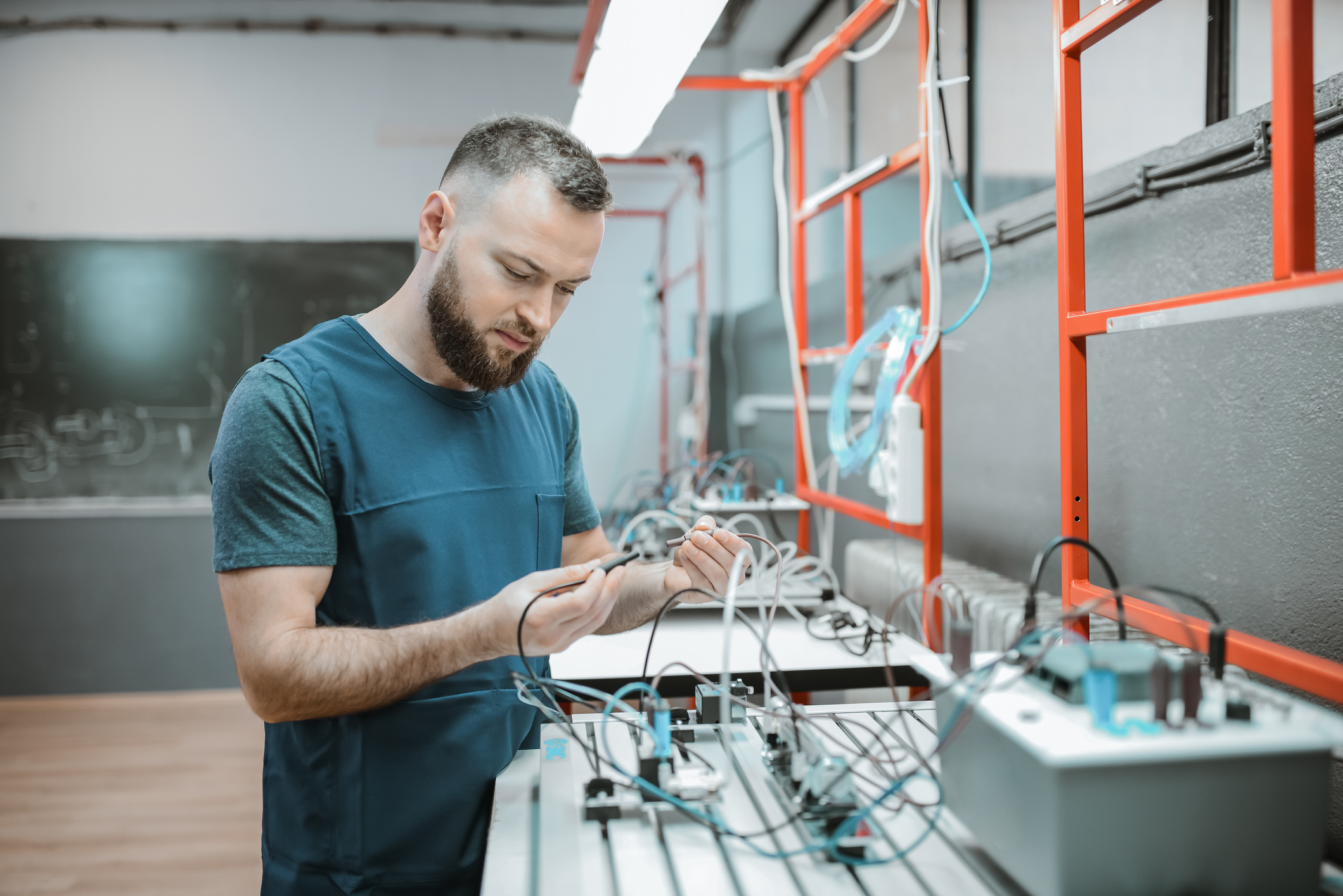 Male Operating Programmable Logic Controller In Classroom